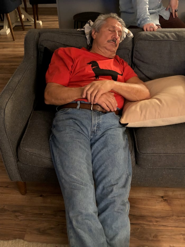 Old man passed out on a couch.