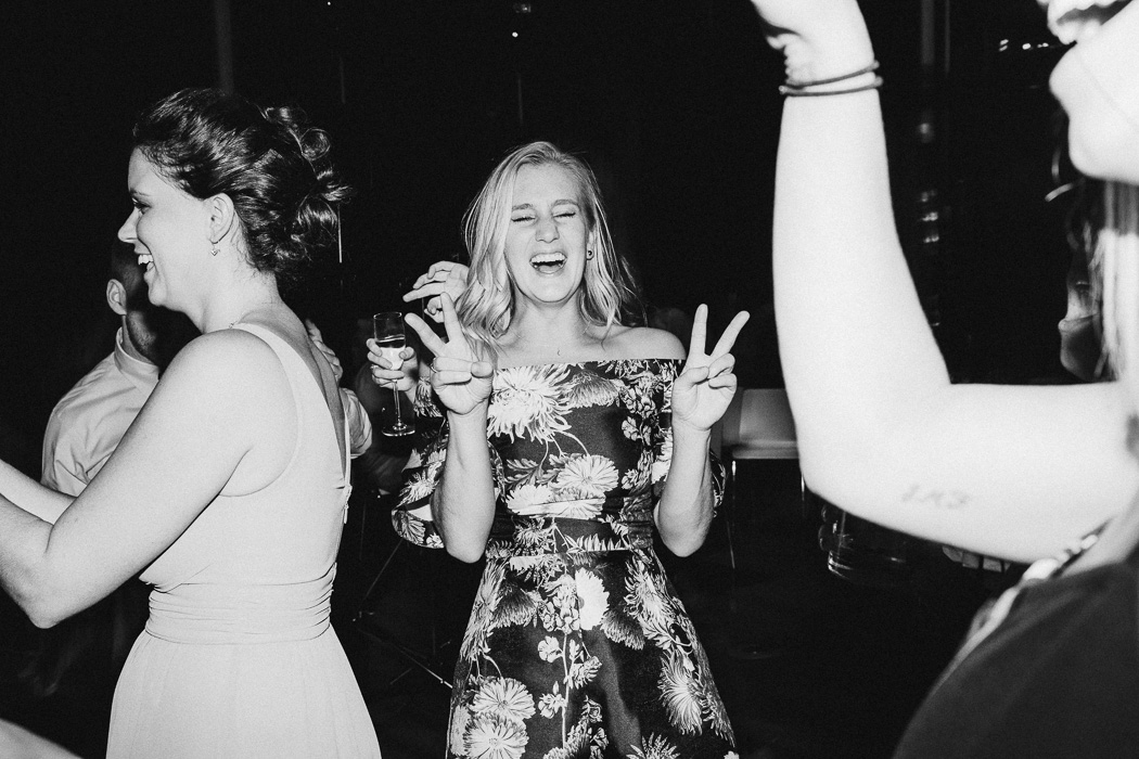 Girl holding up a double peace sign and laughing.