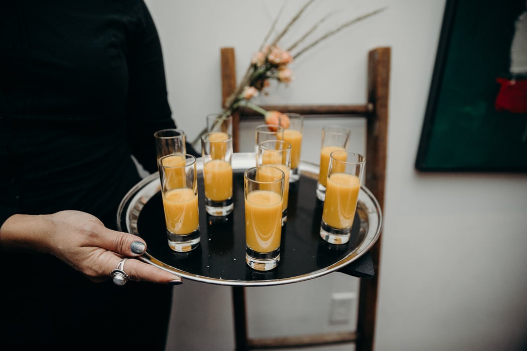Serving platter with soup shooters on it.
