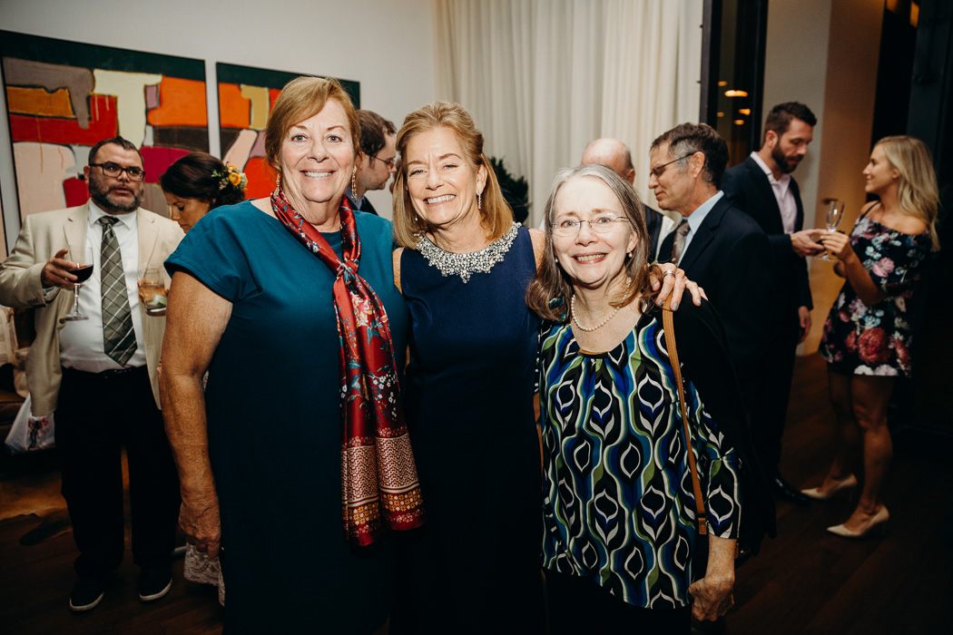 Three sisters posing for a picture at a wedding.