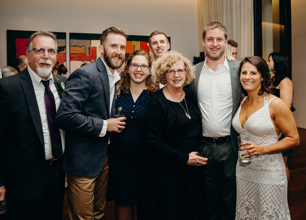 Large group of people with the bride and the groom posing for a picture.