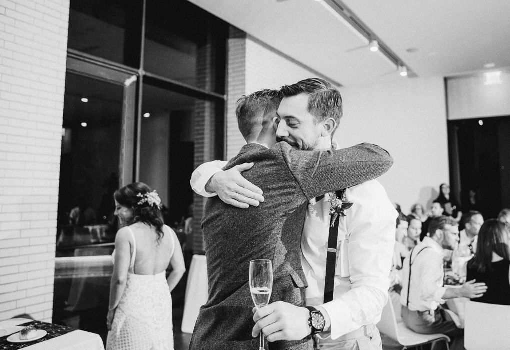 Groom and the best man hugging at a wedding after the best man's speech.