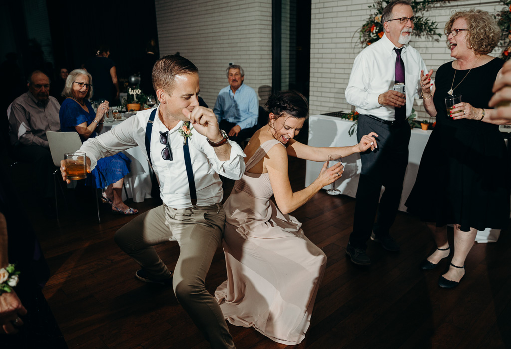 A guy and a girl with dancing with each other with their backs again one another.