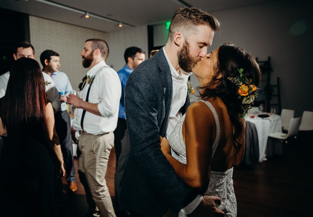 Bride and groom kissing in the middle of the dance floor at their wedding.