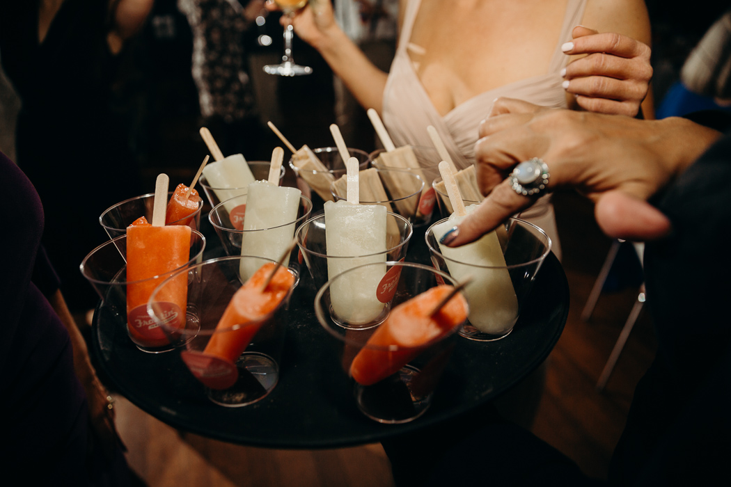 Serving plate of different flavors of popsicles in a cups.