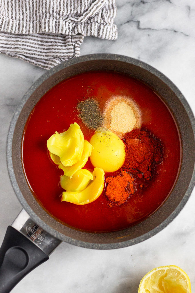 A small saucepan filled with ghee, hot sauce, and spices to make homemade buffalo sauce.