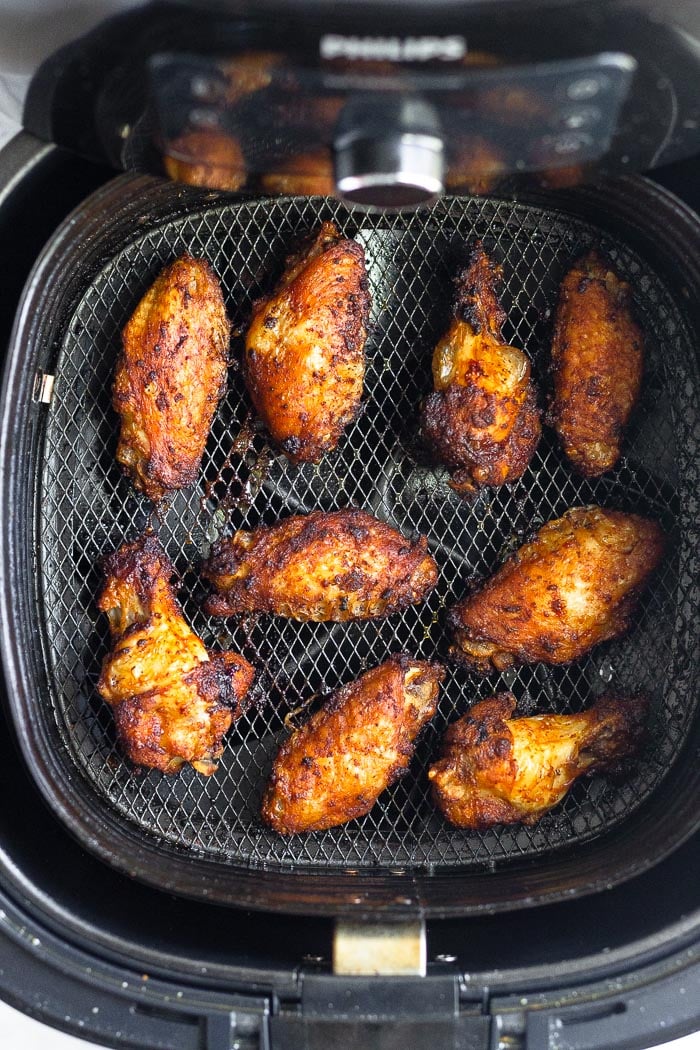 Air fryer chicken wings in an air fryer basket.