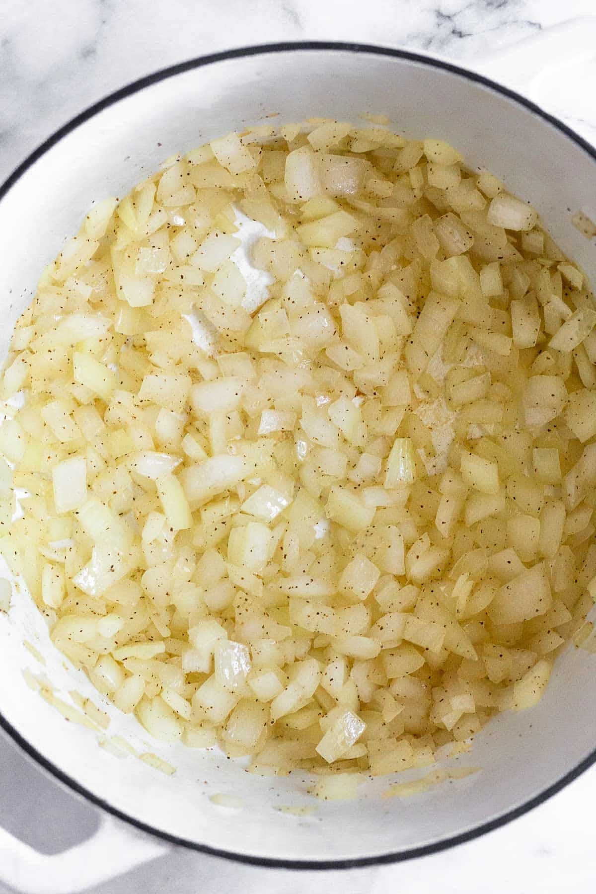 Large dutch oven filled with sautéed onions.