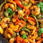 Large pan with shrimp fajitas garnished with cilantro.