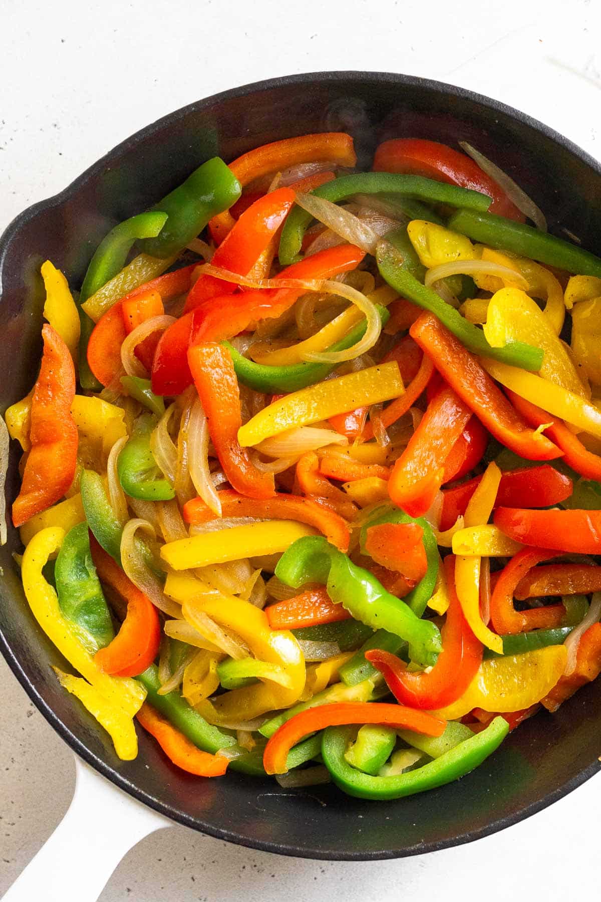Sautéed onions and peppers in a cast iron skillet.