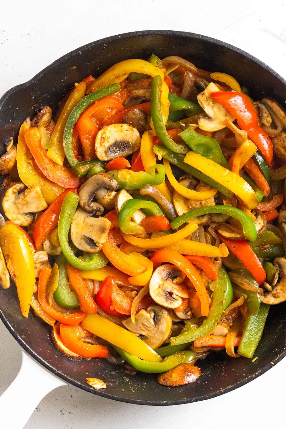 Sautéed onions, peppers, and mushrooms in a cast iron skillet.