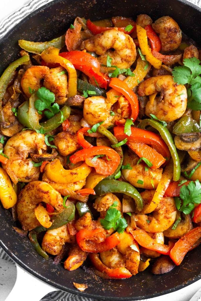 Large pan with shrimp fajitas garnished with cilantro.