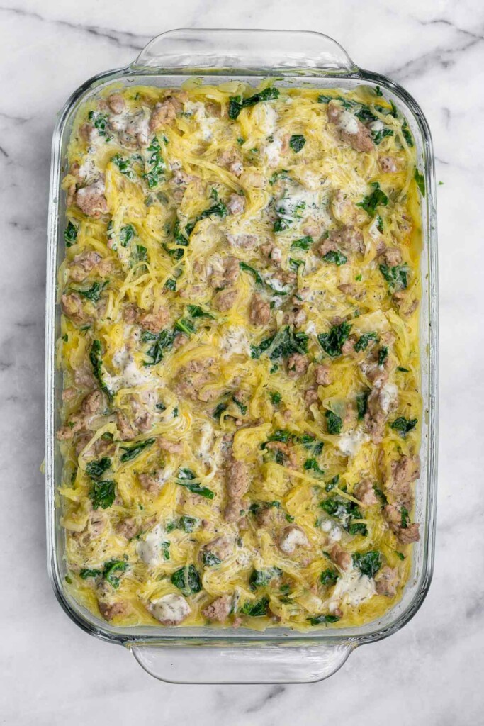 Spaghetti squash casserole with ground turkey, kale, and ranch dressing all mixed together in a large casserole dish before it goes into the oven.