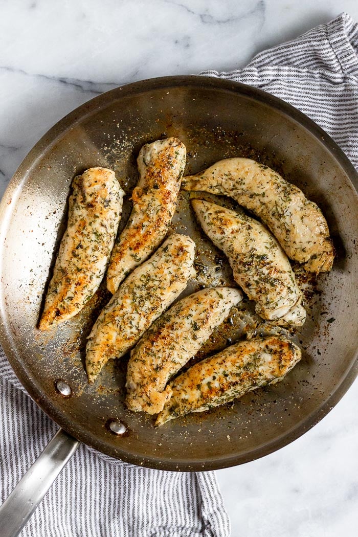 Pan with pan fried chicken tenders in it.