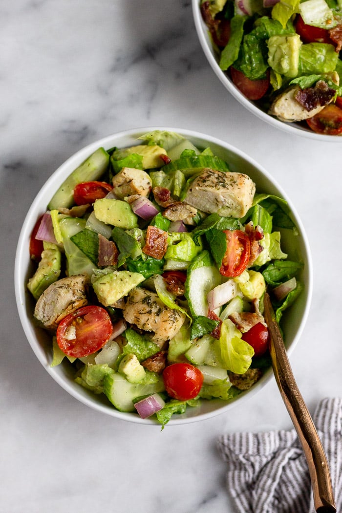 Bowl of chicken bacon ranch salad with another bowl next to it. The main bowl has a fork coming out of it.