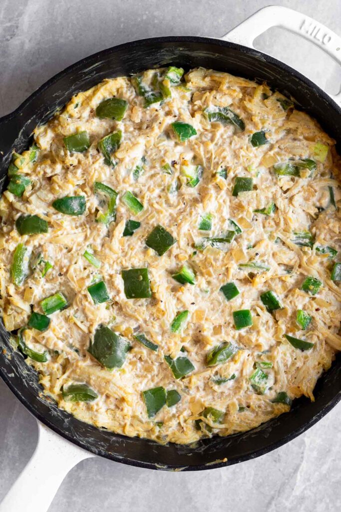 Baked jalapeno chicken popper casserole in a large cast iron skillet.