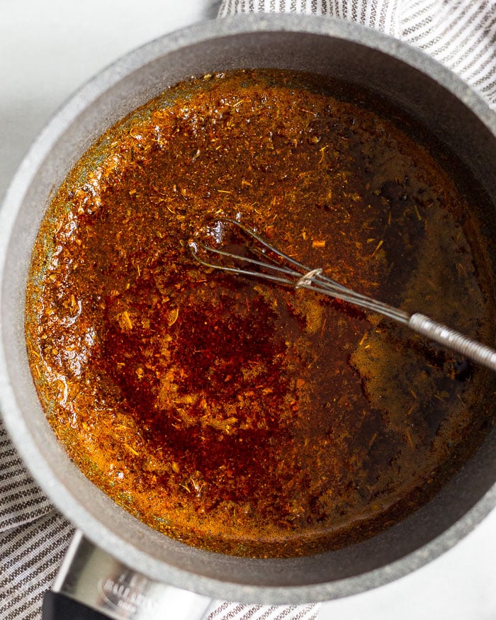 Pan filled with spices and ghee mixed together.
