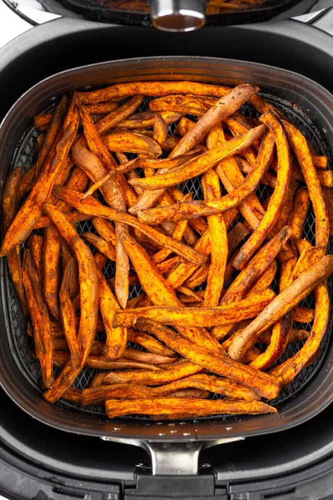 Air fried sweet potato fries in an air fryer basket.