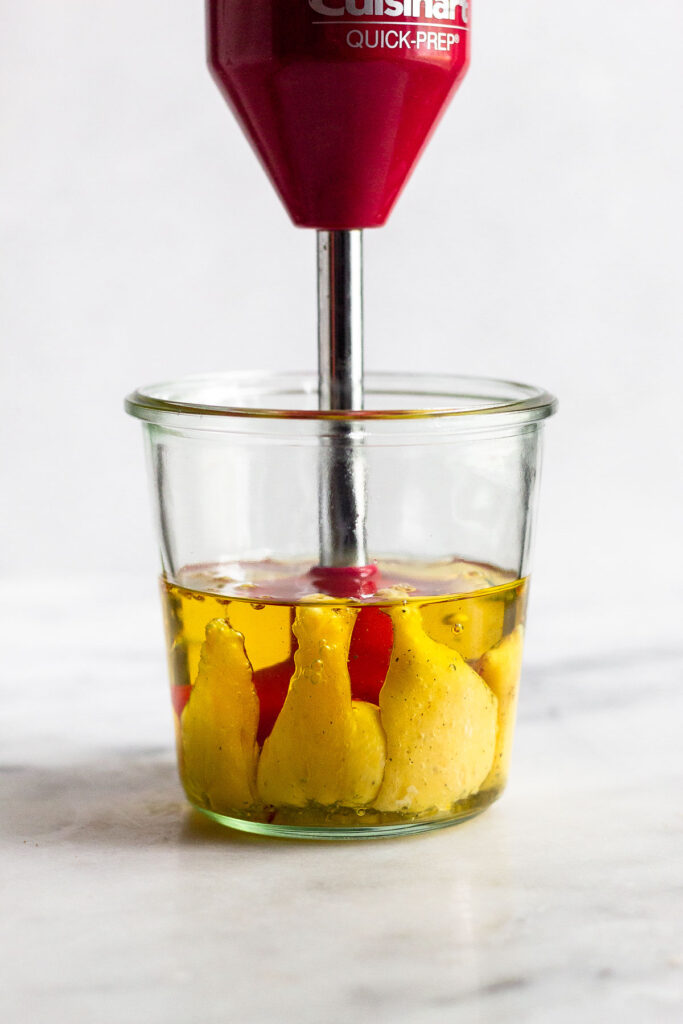 Large jar with an immersion blender in it starting an emulsion for homemade mayonnaise.