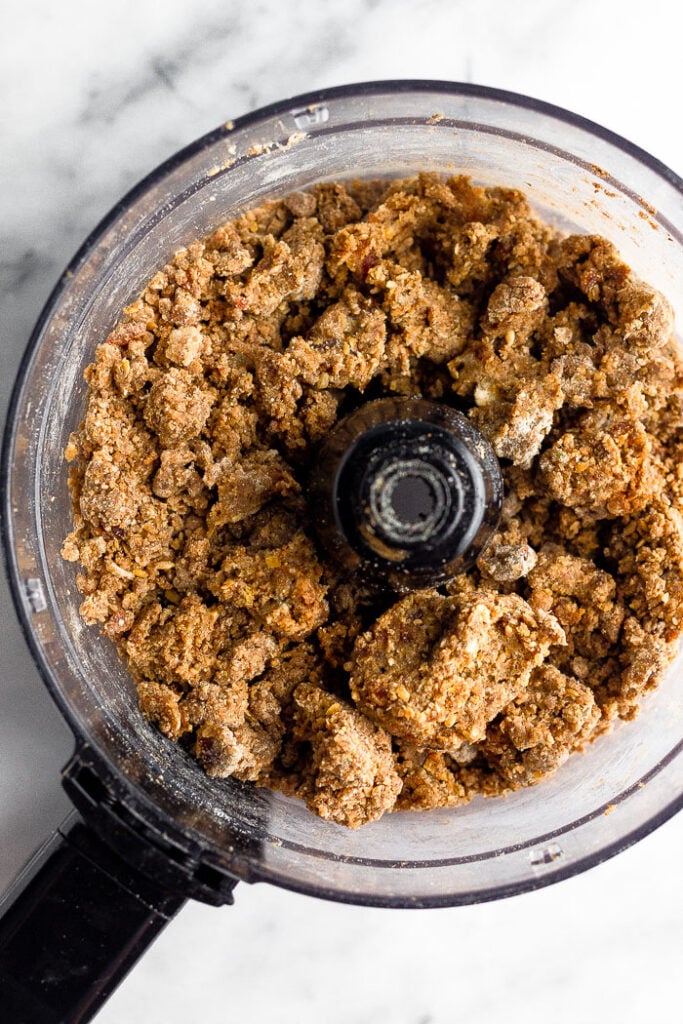 Overhead shot of a food processor filled with the dough to make seed cycling date balls