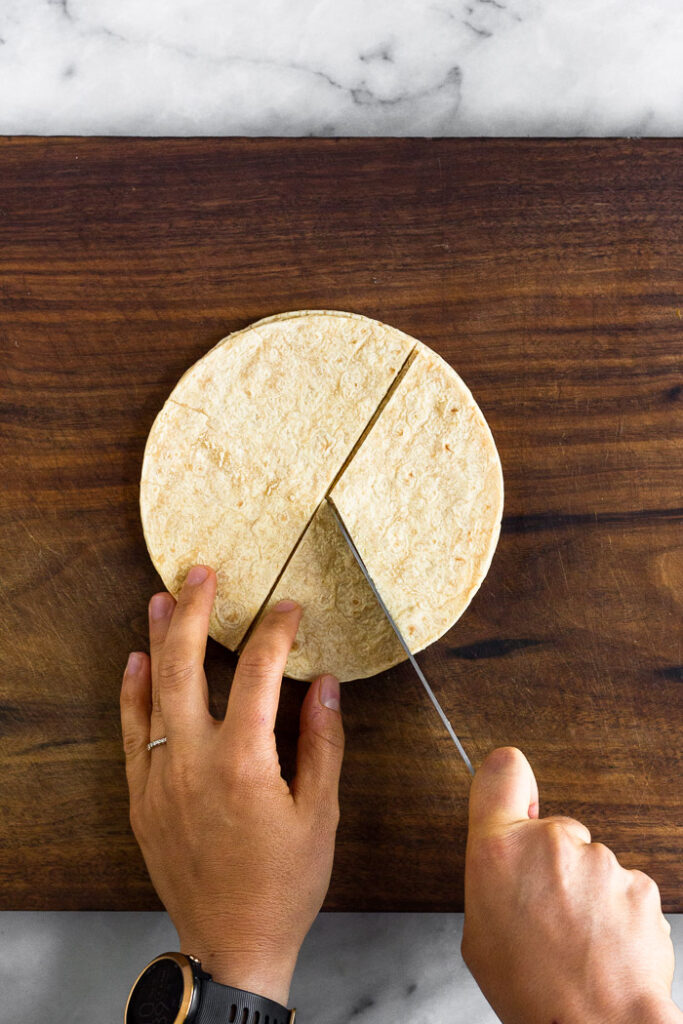 Overhead shot of corn tortillas being cut.