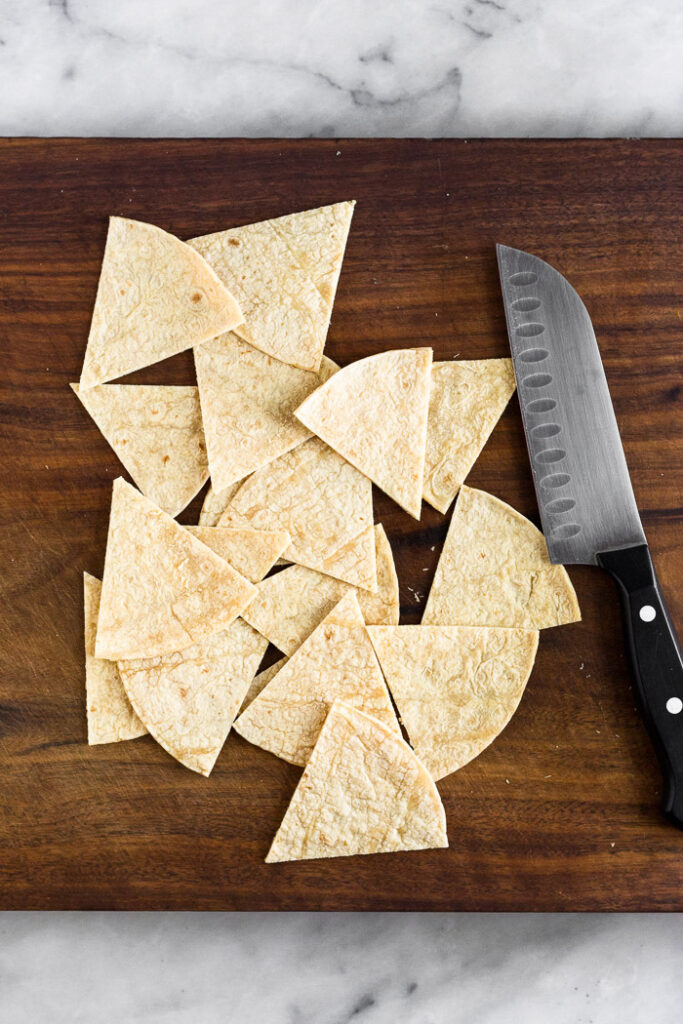 Overhead shot of corn tortillas cut into chips to make homemade corn tortilla chips.