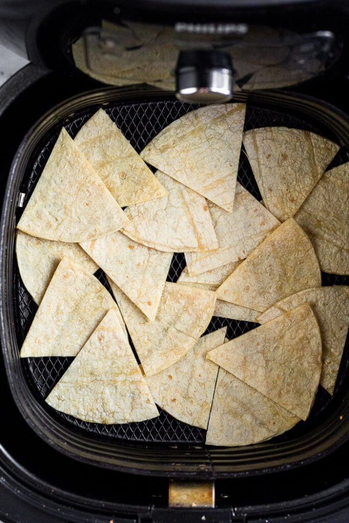 Cut up corn tortillas in an air fryer basket.