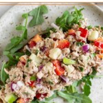Overhead shot of healthy tuna salad without mayo on top of arugula on a piece of toast on a plate.