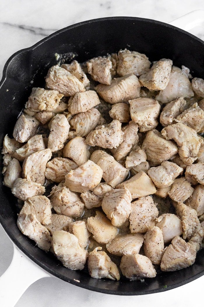 Pan filled with cooked cubed chicken breast.