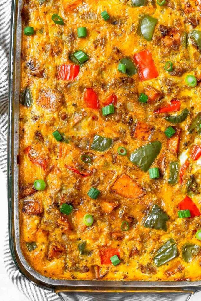 Breakfast casserole with sweet potatoes, sausage, and veggies in a large casserole dish.
