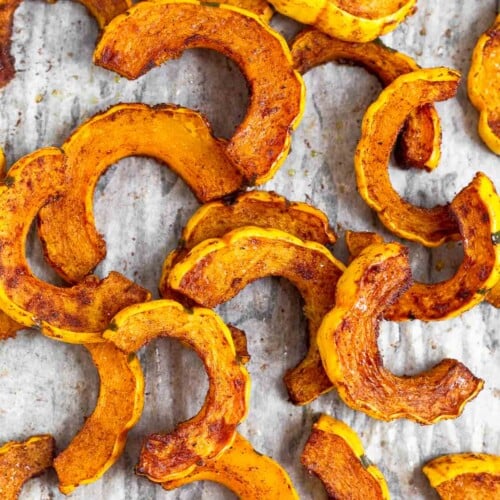Overhead shot of cinnamon roasted delicata squash on a baking sheet.