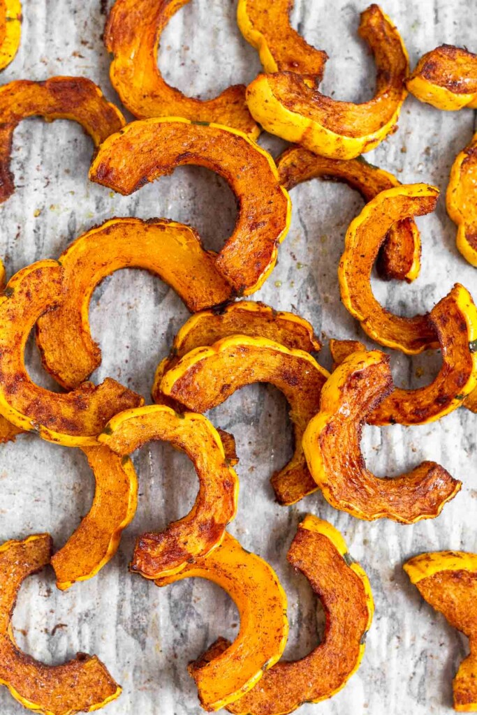 Overhead shot of cinnamon roasted delicata squash on a baking sheet.