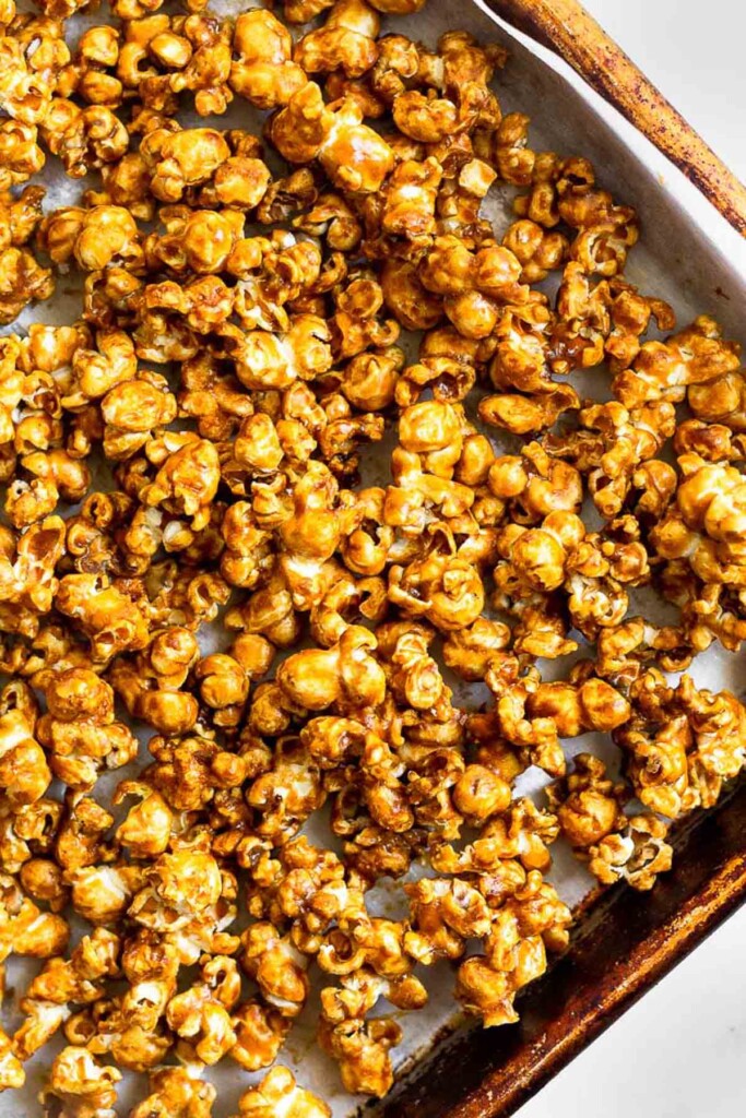 Overhead shot of a large baking sheet filled with homemade caramel corn.