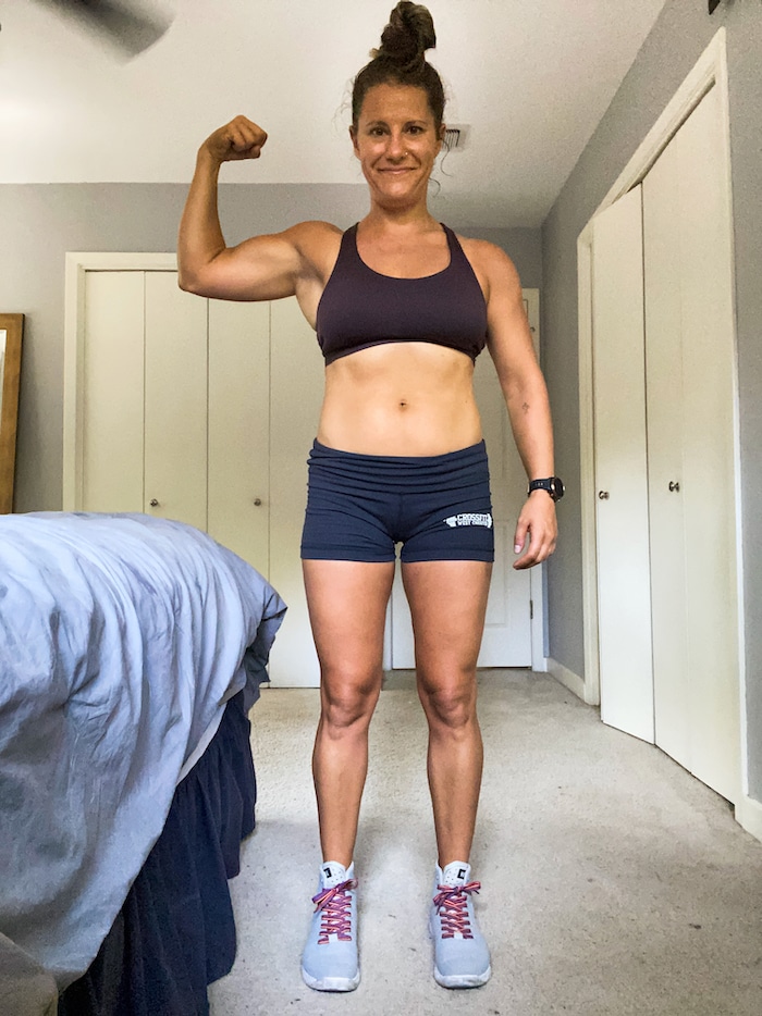 Girl in spandex shorts and a sports bra flexing