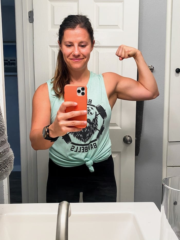 Girl in the mirror taking a selfie and flexing