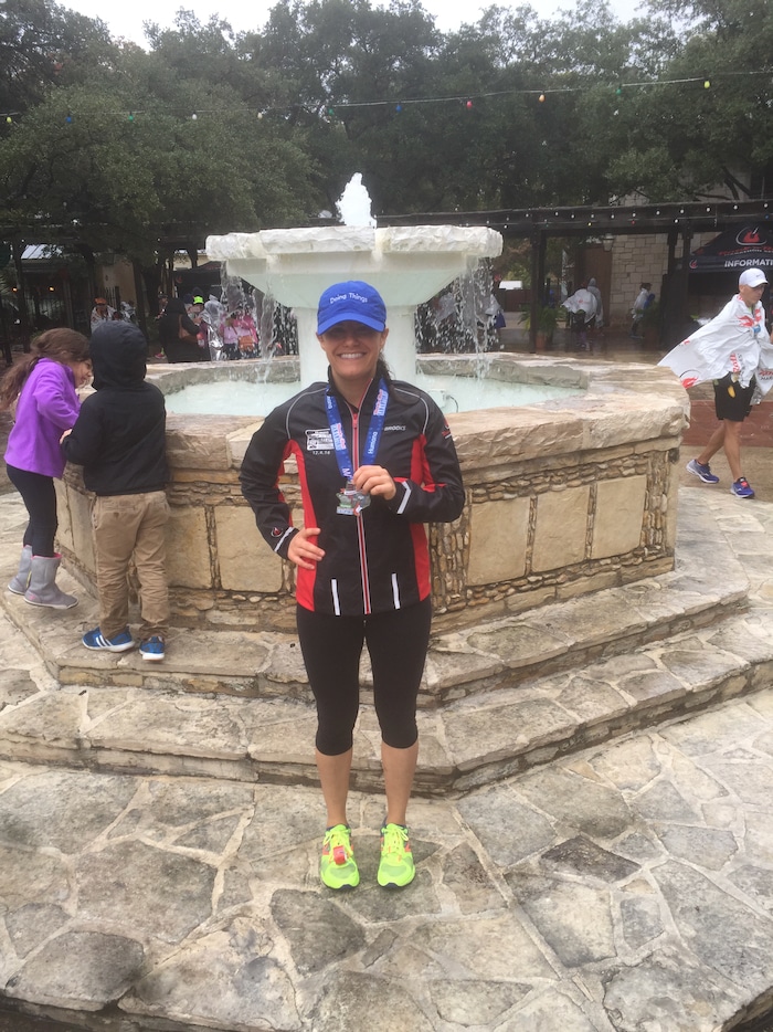 Girl holding a medal after running a race.