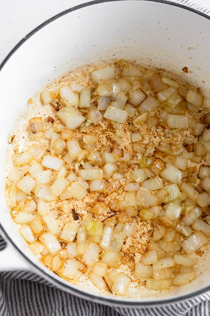 Large dutch oven filled with sautéed onions.