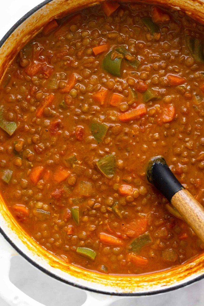 Curry lentil soup in a large pot with a ladle in it.