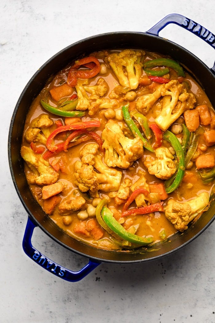 Large dutch oven filled with Cauliflower and chickpea curry with lots of veggies.