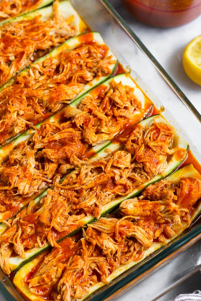 Zucchini boats recipe stuffed with buffalo chicken in a large glass pan.
