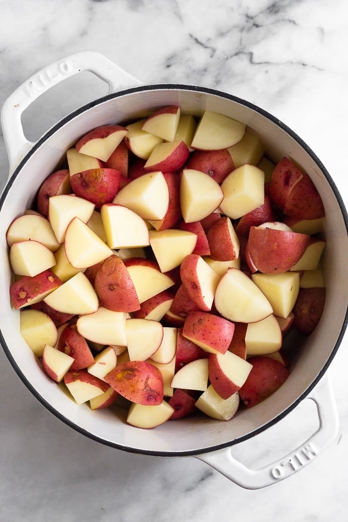Overhead shot of cubed red potatoes in a large stock pot.