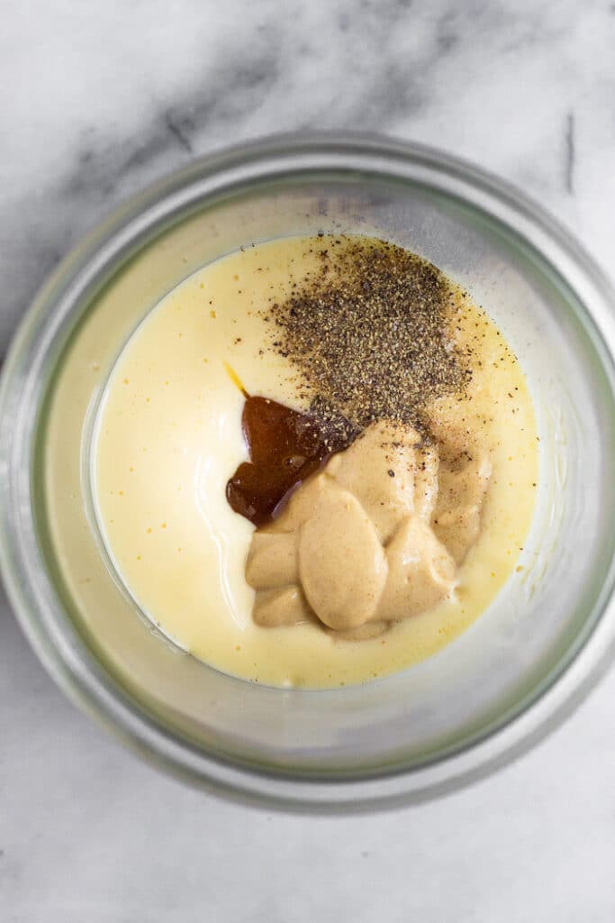 Overhead shot of a jar filled with mayo, honey, mustard, and spices.