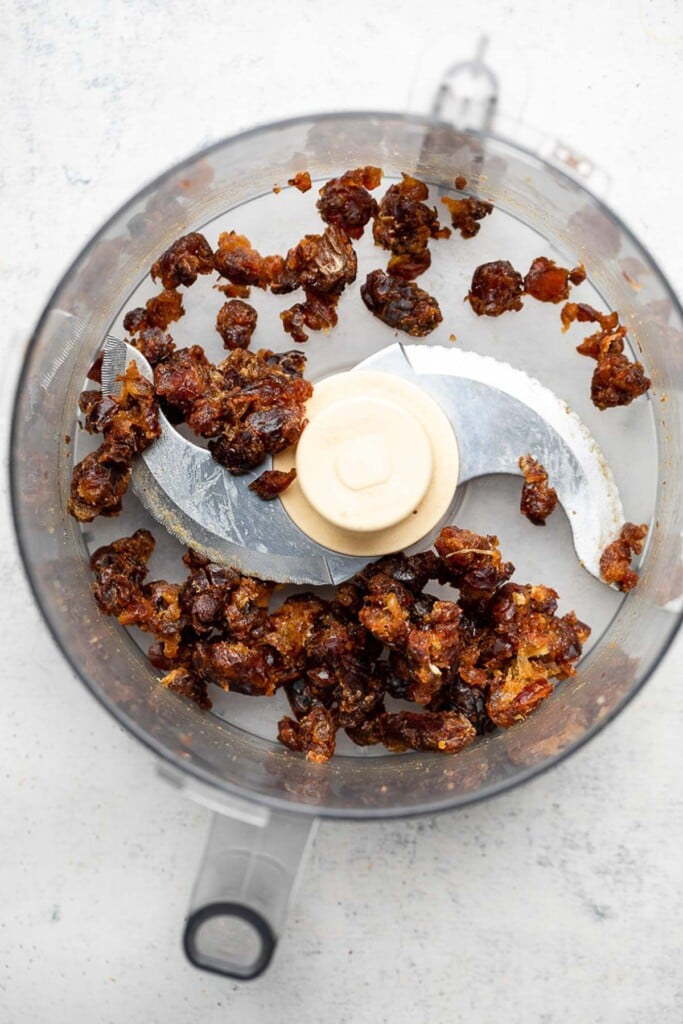 Food processor with broken up medjool dates in it.