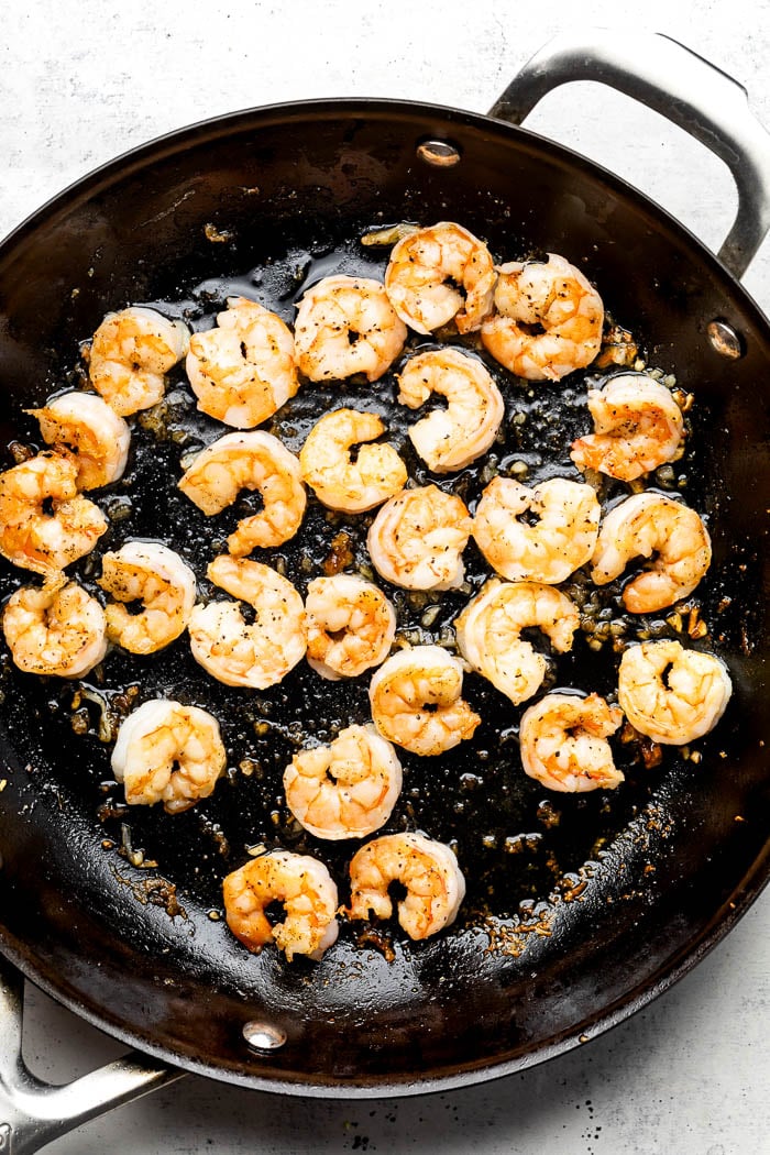 Sauté pan filled with cooked shrimp.
