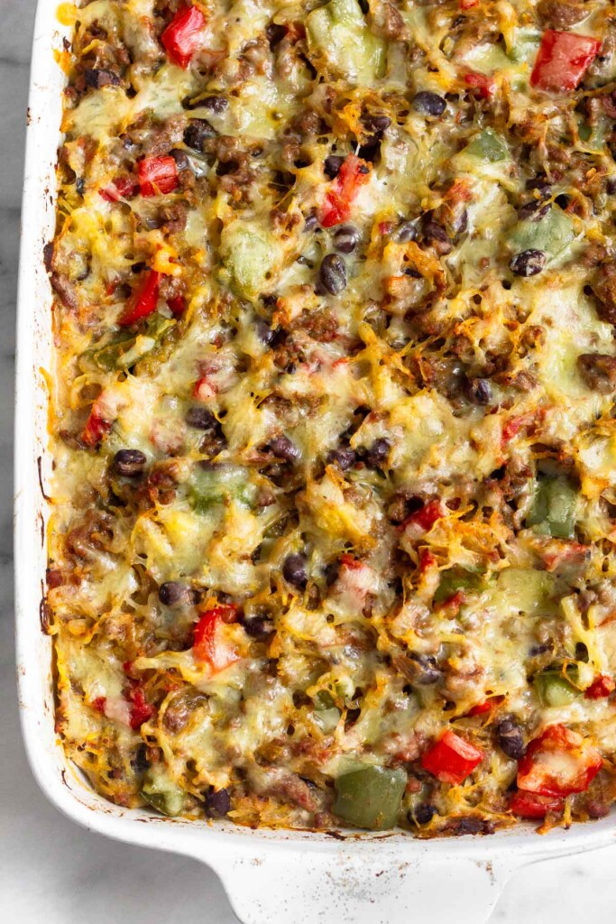 Cheesy spaghetti squash casserole in a large white baking dish.