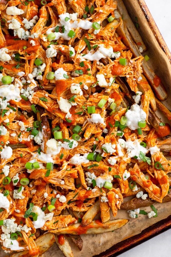 Loaded chicken fries topped with shredded buffalo chicken, blue cheese dressing, blue cheese crumbles, green onion, and parsley.