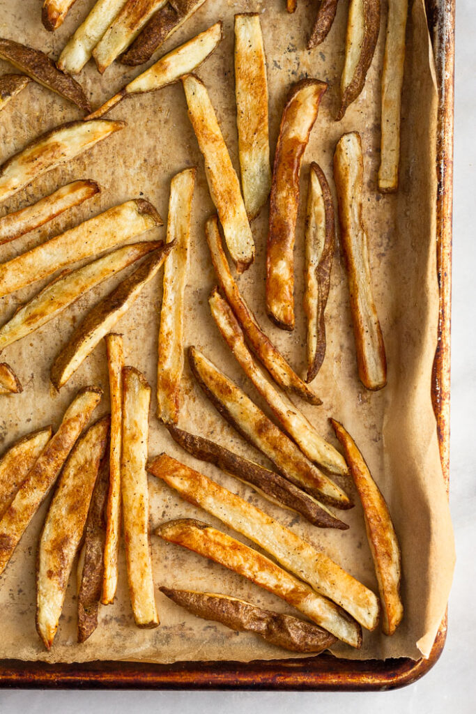 Overhead shot of crispy French fries on a baking sheet.