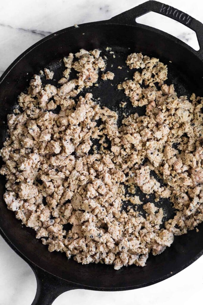 Large cast iron with sautéed ground turkey in it.