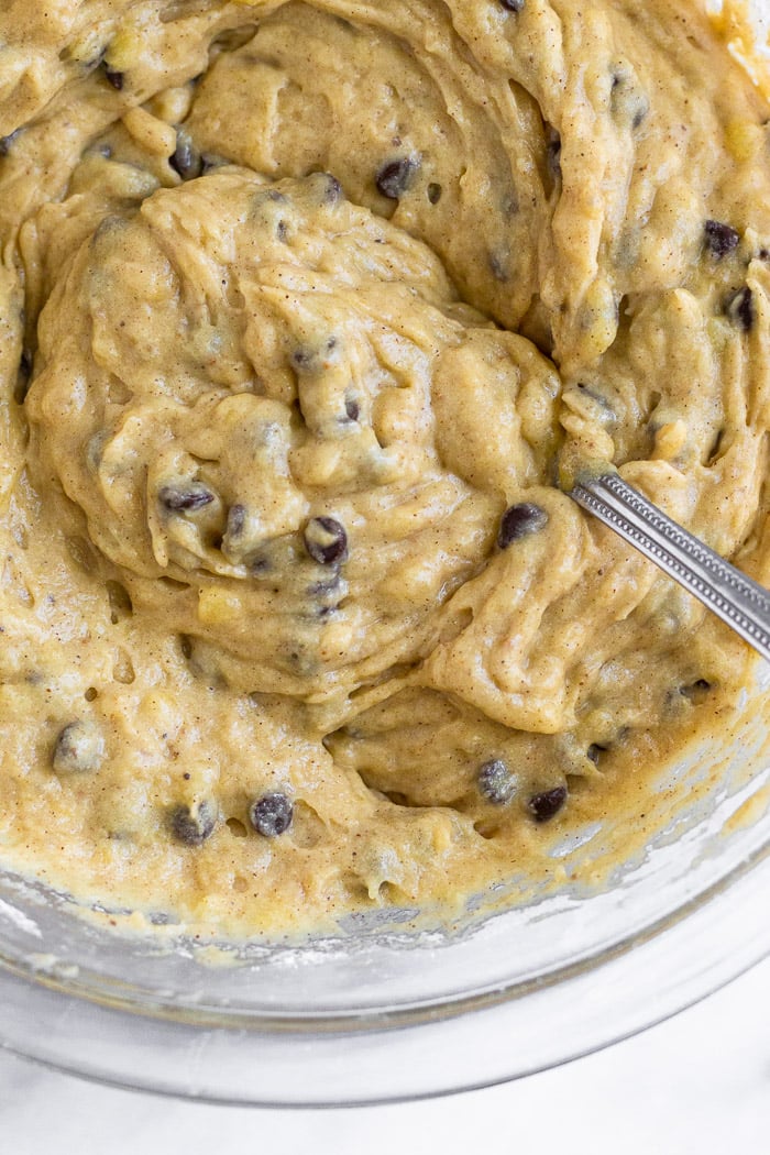 Banana bread chocolate chip bars batter in a large glass bowl with a fork in it.