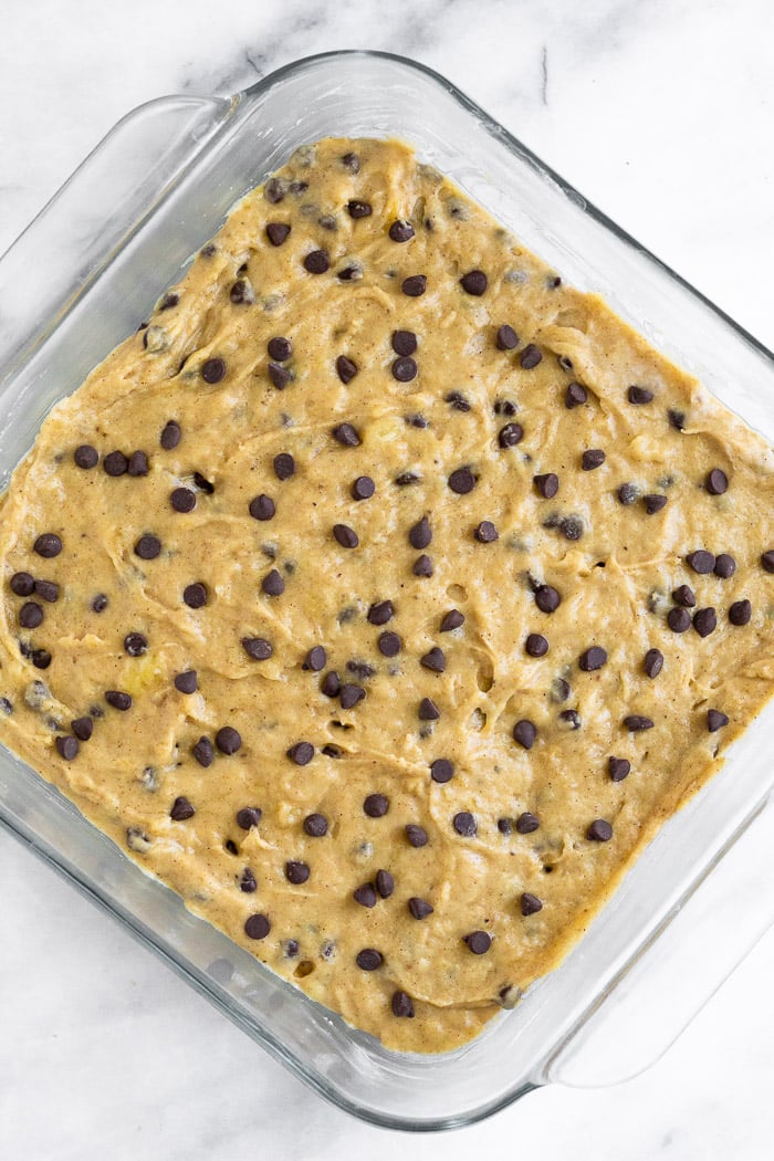 Chocolate chip banana bread batter in a glass baking dish.